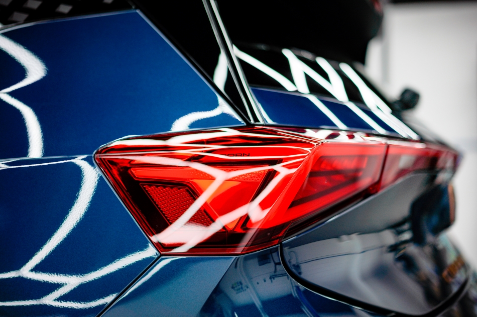 Close-up of red tail light on blue car