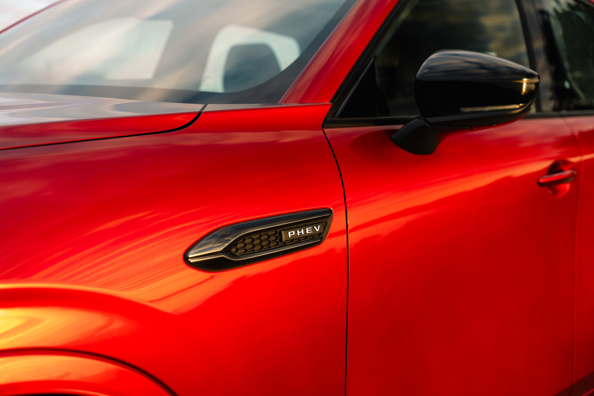 Red PHEV badge on car near side mirror